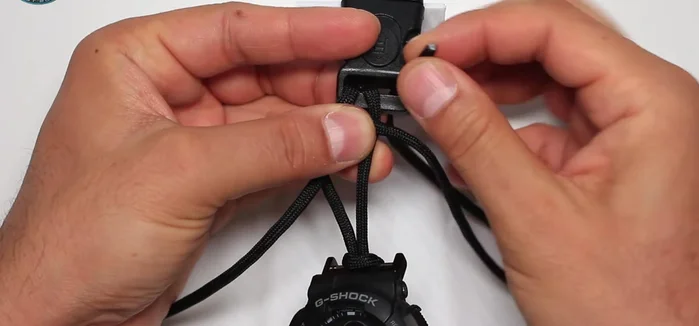 Secure the ends of the black paracord by threading them through the buckle and creating a loop.