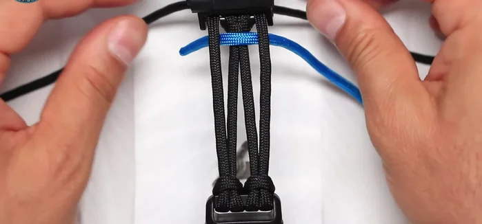 Weave the sky blue paracord around the black paracord, creating a secure attachment. Repeat this on both sides.