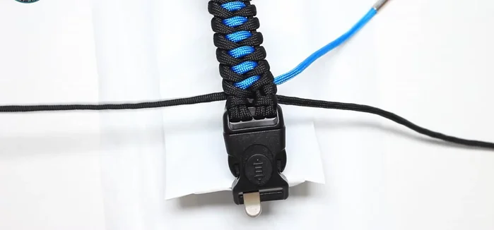 Insert the remaining ends of the sky blue paracord into the cow hitch to lock it and melt the ends from the back side.