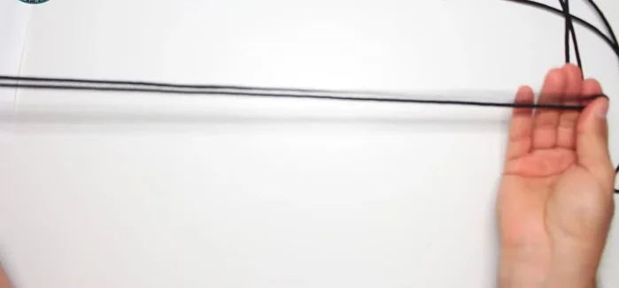 Place the paracord jig in the middle of the watch and insert one end of the black paracord into each side.