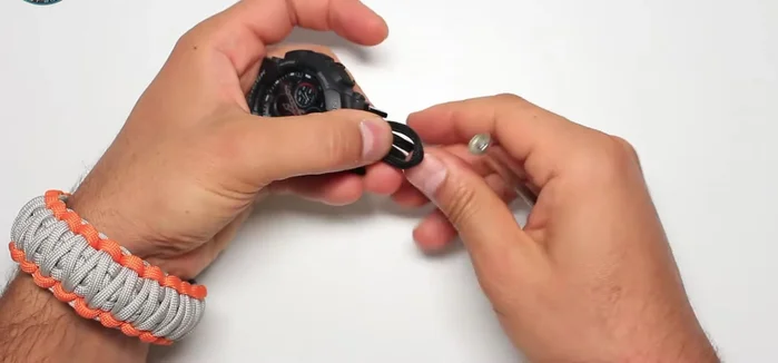 Secure the ends of the black paracord by threading them through the buckle and creating a loop.