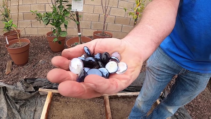 Spread glass beads over the wet concrete. Allow some beads to sink, reserving some for a later, less wet layer. Consider a pattern for better visual appeal (lazy river pattern used in video)