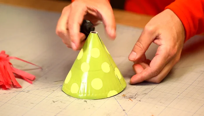 Make a string and thread it through the holes to create a chin strap.