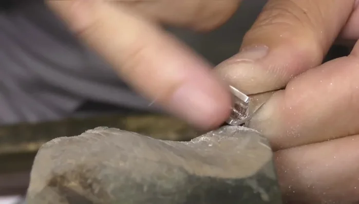 Carefully file the setting to avoid compromising the stone's integrity.