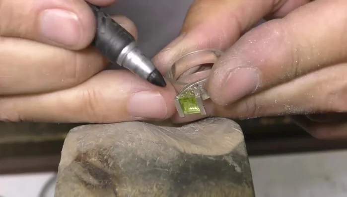 Carefully file the setting to avoid compromising the stone's integrity.