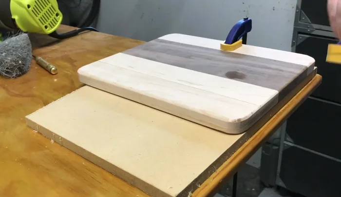 Drill a thumb hole using a Forstner bit and rout out the inside for a smooth finish.