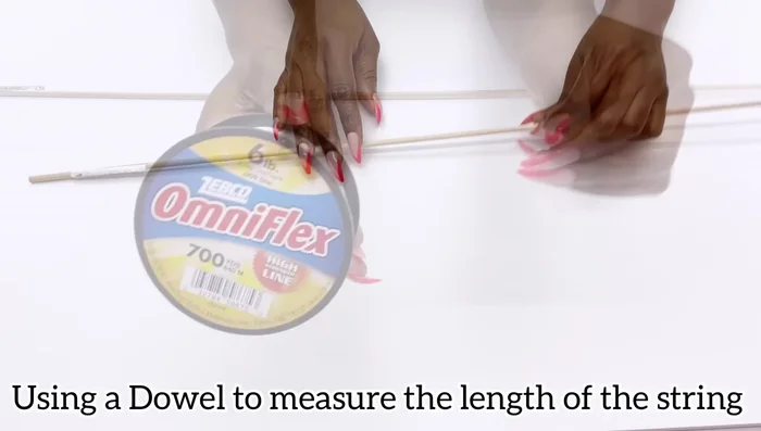 Attach gems to fishing lines using a dowel as a guide for consistent length.