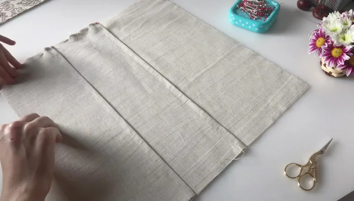 Attach pockets to the main body: Pin the three parts together (two pocket details and one plain main detail), aligning the pockets to create a series of pockets with varying widths (two 2.5cm pockets and one 9cm pocket). Stitch in place.