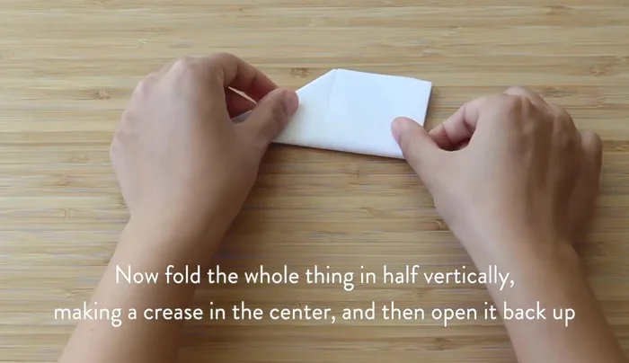 Find the vertical center by folding the paper in half vertically, then open it.