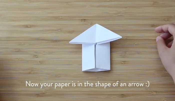 Fold the stem of the arrow shape in half to shorten it.