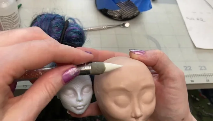 Smooth out the entire head using a silicone tool, clay softener, and a soft brush to remove lumps and fingerprints.