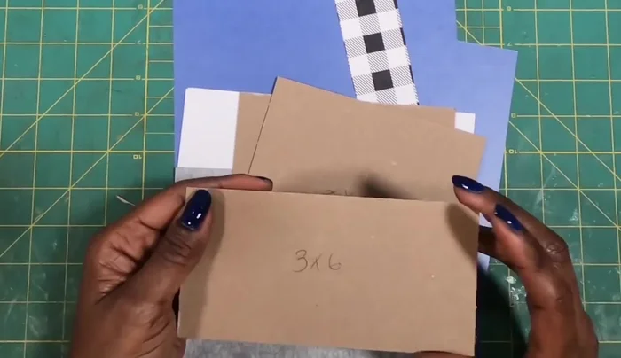 Prepare Chipboard and Paper Pieces: Cut and score chipboard and paper to the specified dimensions. (See transcript for measurements)