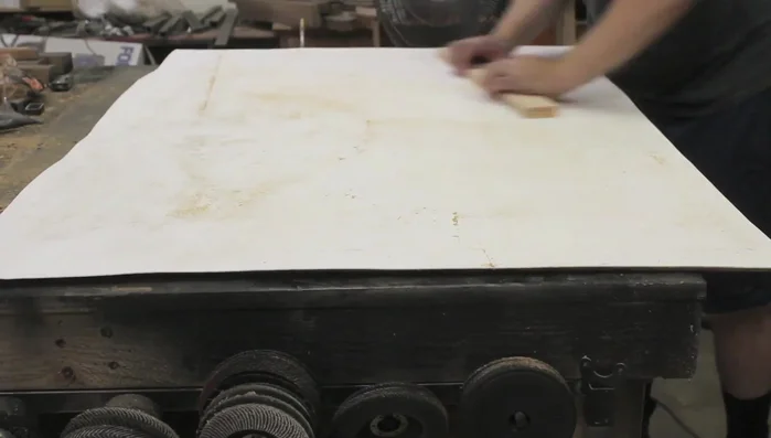 Apply contact cement to adhere a layer of poly wall to the plywood backing to prevent the wood grain from showing through the paint and to protect against gouges. Then paint with chalkboard paint.