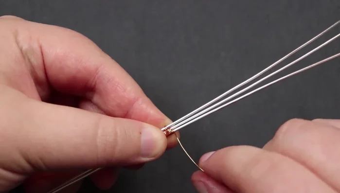 Create pyramids: Create three pyramids on each side, using the weaving wire to create a small pyramid shape with each section of two wraps. Make sure to maintain loose spacing between the base wires.