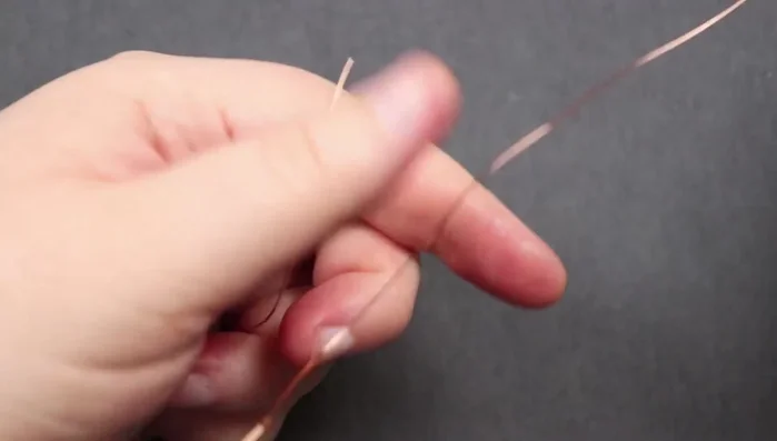 Attach the bead: Thread one end of the weaving wire through the bead, then the other end from the opposite direction. Gently pull the bead down to the base of the piece.