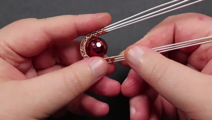 Secure remaining base wires: Wrap and secure the remaining base wires in the same manner, making sure to tuck the ends securely into the back of the piece.