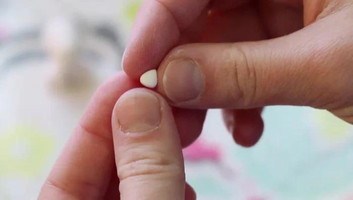 Create ears: Pinch two small balls of white clay into triangle shapes and attach them to the head.