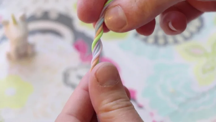 Create the mane and tail: Twist together pastel-colored clay and attach it to the back of the head and body to form the mane. Create a tail using more twisted clay and blend the bottom.