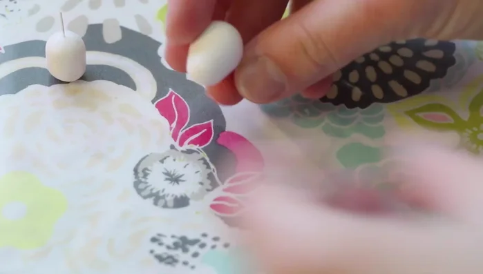 Add legs: Roll out teardrop shapes for the back legs, flatten the bottom, and attach them to the body. Use smaller balls for the front legs, attaching and blending them in.