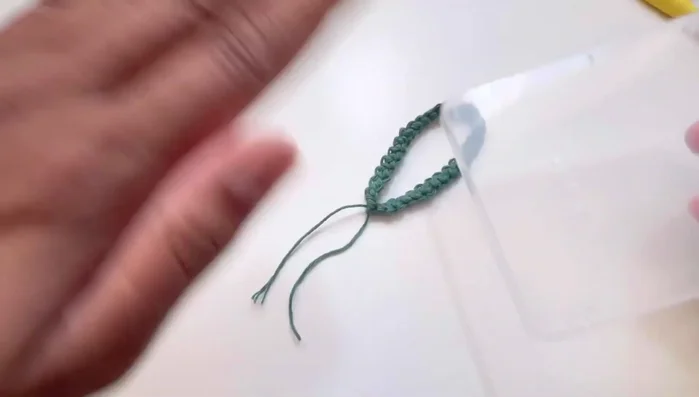 Insert the hook near the wrapped yarn, gather the yarn loops, and secure with a separate piece of yarn. Tie several knots to secure.