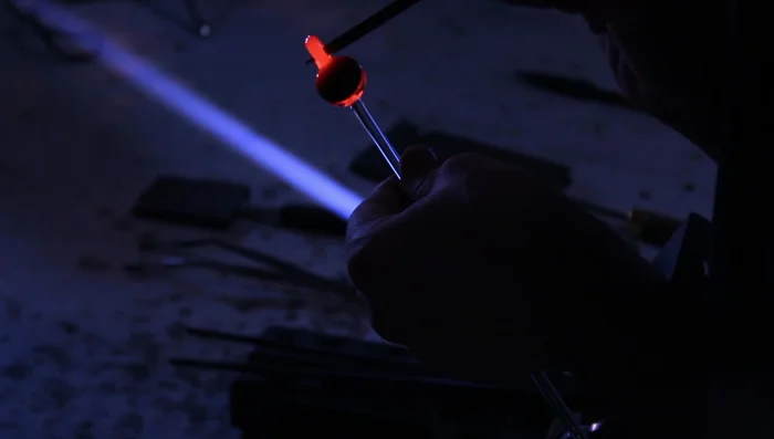 Melt and smooth the loop, ensuring it is wide enough for a cord.