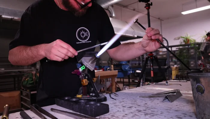 Melt and smooth the loop, ensuring it is wide enough for a cord.