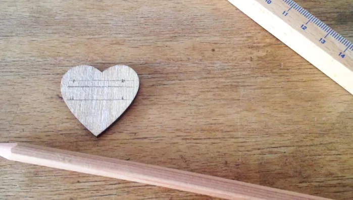 Prepare the wooden hearts by sketching the herb names with a pencil.