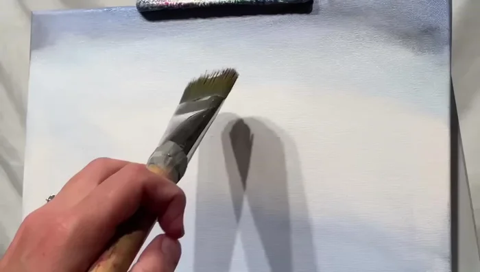 Using the number 30 filbert brush and a mix of blue violet and a tiny bit of black, create puffy clouds with half-circle strokes.