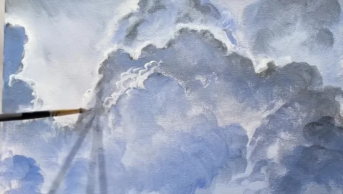 Continue layering clouds with varying shades and intensities, creating depth and realism.