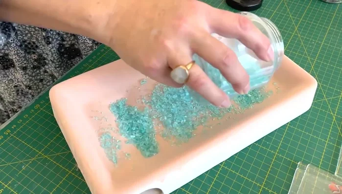 Embed marine life: Carefully place marine life embellishments (fish, shells, anemones) into the glass layers.