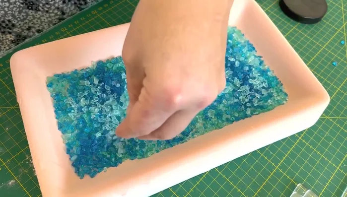 Embed marine life: Carefully place marine life embellishments (fish, shells, anemones) into the glass layers.