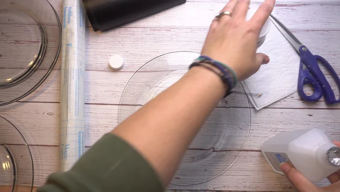 Carefully transfer the vinyl design to the back of the plate, using a scraper to remove any air bubbles. Work slowly and methodically.