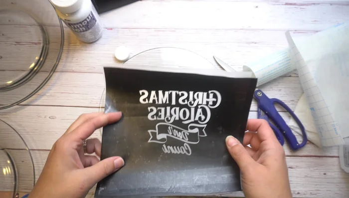 Carefully transfer the vinyl design to the back of the plate, using a scraper to remove any air bubbles. Work slowly and methodically.