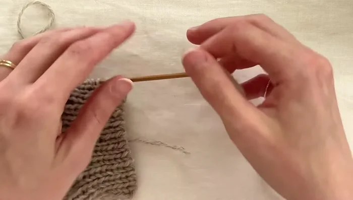 Join button band to cardigan: Knit two stitches together through the back loop to join the cast-on stitches to the picked-up stitches.