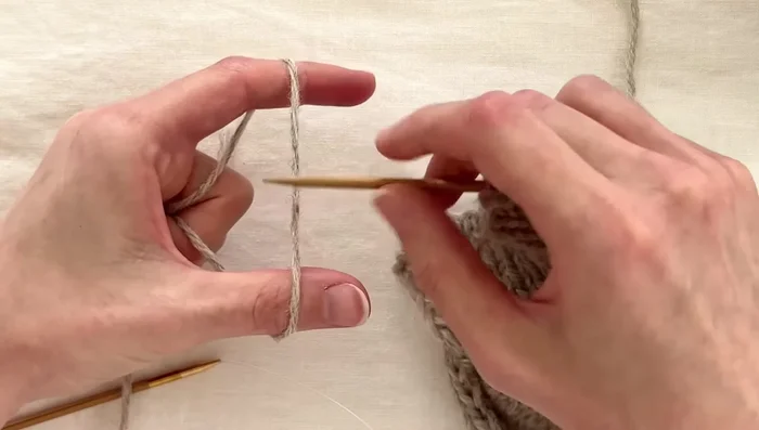 Work double knitting rows: Continue the double knitting pattern until you reach a buttonhole marker.