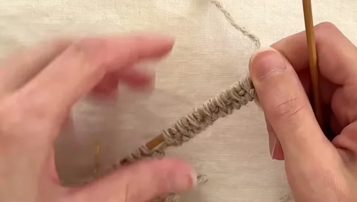 Work double knitting rows: Continue the double knitting pattern until you reach a buttonhole marker.