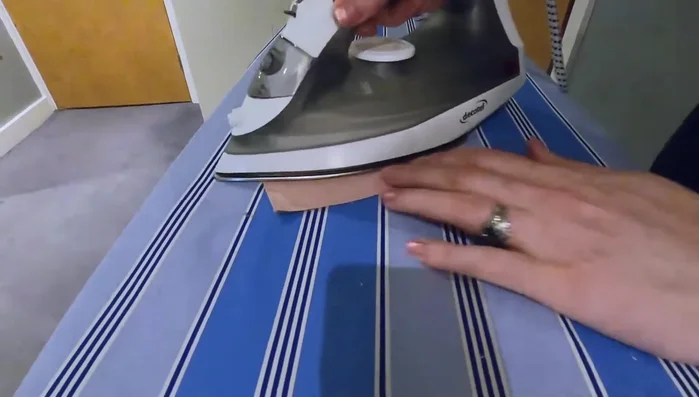 Press a quarter inch seam allowance into the top of each pocket, and press the bottom up.