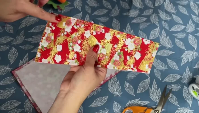 Attach the Pocket: Turn the pocket piece inside out, iron flat. Attach the pocket to the main wallet piece by sewing along the top edge.