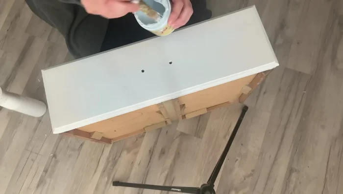 Shade with Dixie Belle Dusty Blue, creating a gradient effect from darker at the bottom to lighter at the top. Use a damp cloth to blend for a soft transition. Focus on the bottom and sides of the dresser, slightly blending upwards.