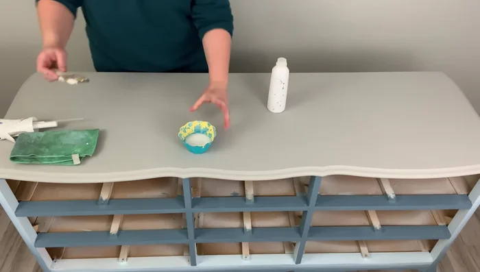 Whitewash the top using Rust-Oleum Chalked Paint in White Linen, diluted with water. Apply multiple thin layers for the desired level of distressing. Use a lint-free cloth to remove excess paint for a smooth, uniform look.