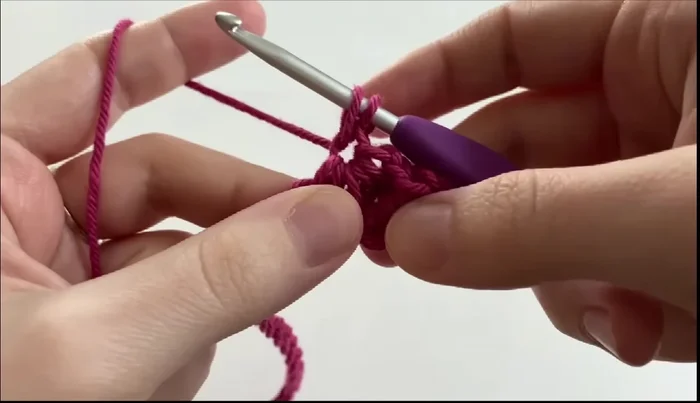 Repeat the star stitch pattern across the row. There will be two chains remaining at the end of the row. Complete the last stitch the same way, ending with a chain one.