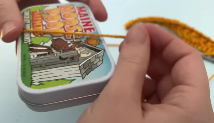 Shape the tassel: Wrap a new piece of yarn around the tassel 3-4 times and secure with a double knot. Trim the tail.