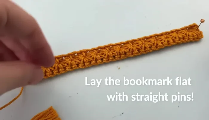 Block the bookmark: Use straight pins to stretch the bookmark, making it straight. Use a spray bottle or steamer to dampen the fabric, keeping the steamer 1-2 inches away. Gently pat the water or steam into the fabric. Remove pins once dry.
