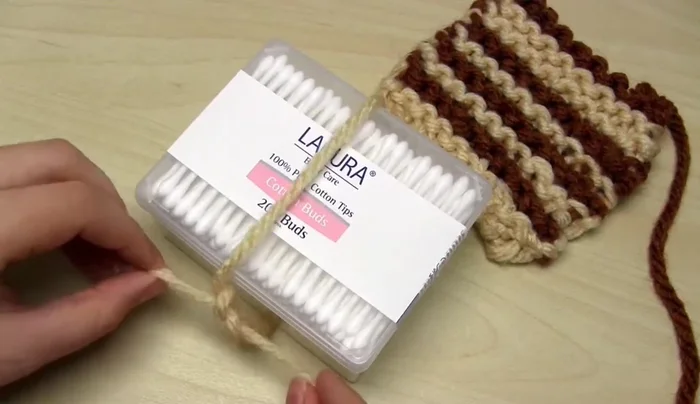 Cut the wrapped yarn on one side to create the strands. Separate the strands into groups according to your desired tassel size.