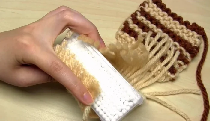 Cut the wrapped yarn on one side to create the strands. Separate the strands into groups according to your desired tassel size.