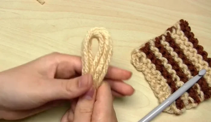 Put your fingers through the loop, grab the yarn ends, and pull them through to tighten the knot.
