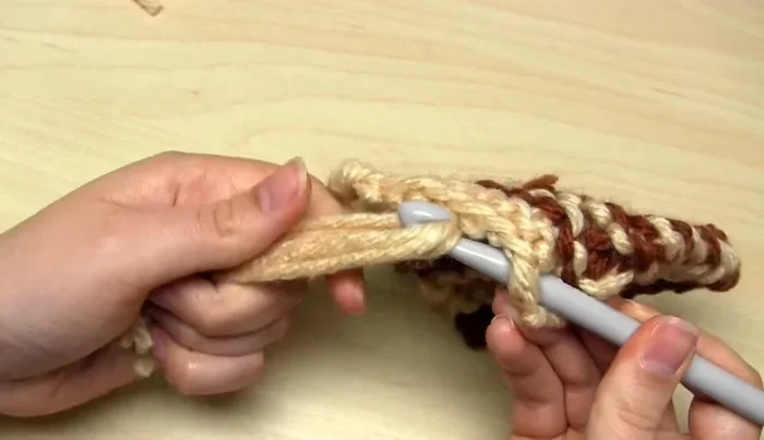 Put your fingers through the loop, grab the yarn ends, and pull them through to tighten the knot.