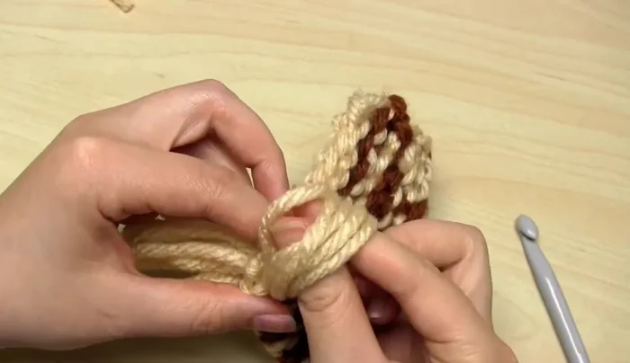 Put your fingers through the loop, grab the yarn ends, and pull them through to tighten the knot.