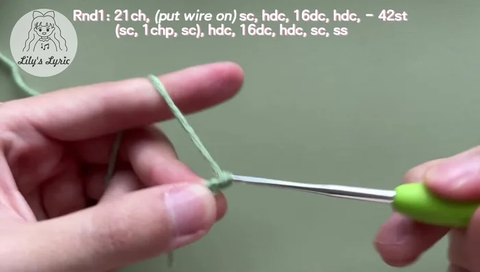 Make a slip stitch, work back into the last chain and make another single crochet. Work into stitches on the other side: half double crochet, 16 double crochets, half double crochet, and single crochet. Slip stitch in the first stitch to fasten off. Weave in the yarn ends.