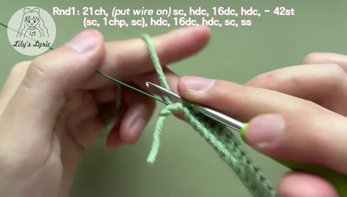 Make a slip stitch, work back into the last chain and make another single crochet. Work into stitches on the other side: half double crochet, 16 double crochets, half double crochet, and single crochet. Slip stitch in the first stitch to fasten off. Weave in the yarn ends.